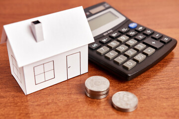 Housing layout, calculator and coins on the table. The concept of buying real estate, real estate market.