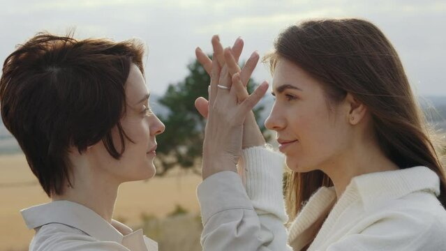 Couple of lesbians holding hands and looking on each other