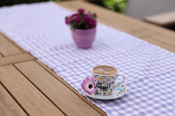 cup of  Turkish coffee with flowers on wooden table
