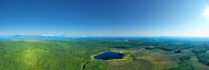 Flight over the taiga blue forest lake. View from above
