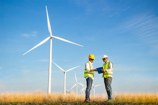 engineer team working in wind turbine farm. Renewable energy with wind generator by alternative energy concept.