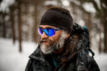 Fototapeta na wymiar man in sunglasses with gray beard in winter jacket