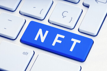 NFT or Non Fungible Token text on blue computer Keyboard Key