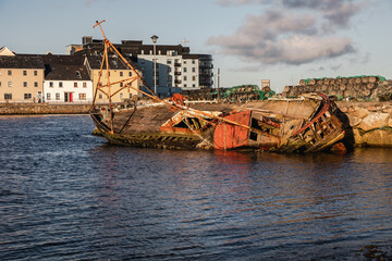 Old wooden shipwrecks in Claddagh Bay, Galway, sunny day in beautiful and popular tourist spot with...