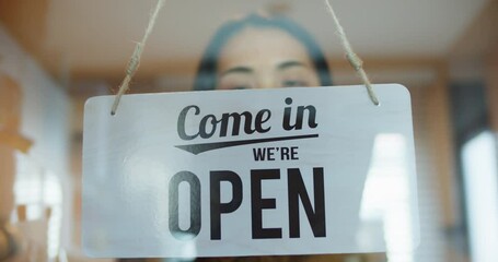 Asian young woman worker flipping sign "Closed" to "open" store for ready service.