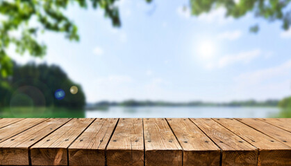 Empty old wooden table with summer lake in background