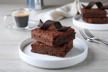 Delicious chocolate brownies served on white wooden table