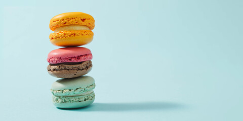 Cake macaron or macaroon on turquoise background from above, colorful almond cookies, pastel colors, vintage card.