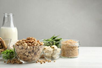 Different organic soy products on white wooden table, space for text
