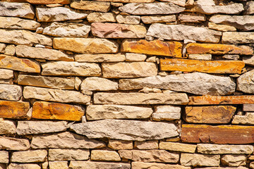 Masonry wall of old stone blocks of limestone. Background texture of ancient brick wall