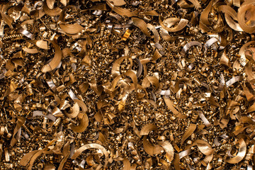 Golden pieces of metal filings photographed in close-up macro in a metal factory
