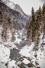 A narrow mountain river in the winter mountains