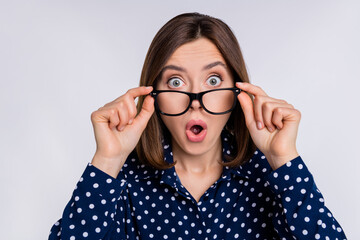 Photo of young impressed woman hands touch eyeglasses watch news rumor isolated over grey color...