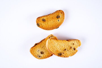 Slised bread with raisins isolated on white background, top view. Raisin rusks biscuits cookies isolated on white background. Three pieces of sweet dry hard bread chucks crackers with raisins.