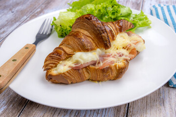 baked ham croissant in a plate with salad