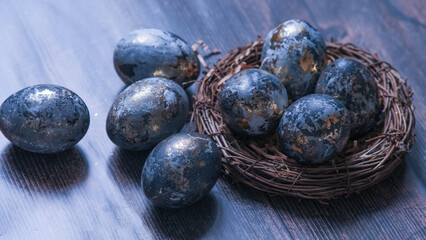 Easter card with a copy of the place for the text. Very Peri 2022 .Purple, blue eggs in a basket on a dark newspaper background. Natural dye karkade tea.