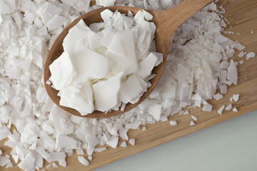 Soy wax - ingredient for handmade candles on wooden spoon - obrazy, fototapety, plakaty