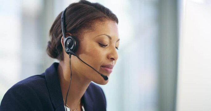 Its In Her Nature To Be Helpful. 4k Video Footage Of An Attractive Young Female Callcenter Agent Working On A Desktop In Her Office.