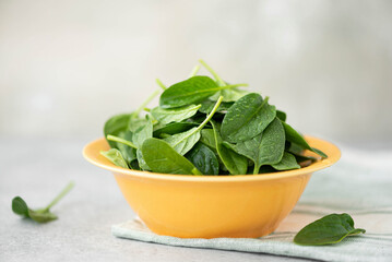 fresh washed spinach leaves in a yellow bowl