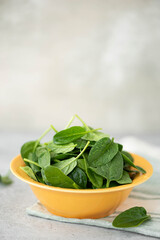 fresh spinach leaves in a yellow bowl