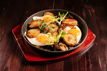 Fried potatoes with egg in a pan. Fine dinning menu.