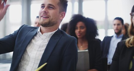 Focused on learning as much as possible. 4k video footage of a handsome young businessman asking questions and taking notes during a conference.
