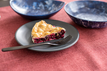 Blueberry pie slice on a plate with a fork