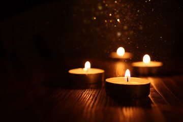 Burning candle over black background