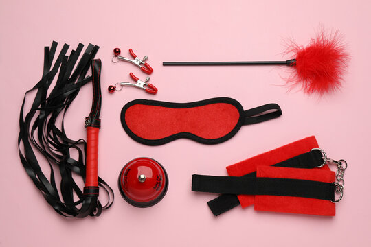 Sex toys and accessories on pink background, flat lay
