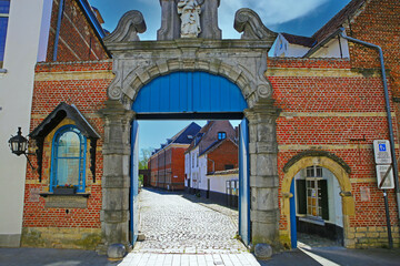 Fototapeta na wymiar Lier (Begijnhof), Belgium - April 9. 2022: View on red brick stone entrance gate of medieval belgian unesco world heritage site village