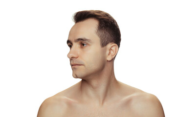 Portrait of young handsome man with clean face, perfect skin, shirtless posing isolated over white studio background. Looking left side