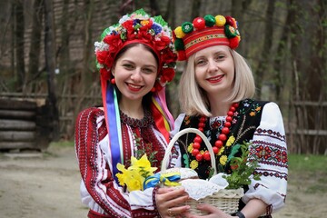 Beautiful girls in Ukrainian national costumes with easter basket