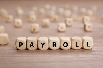 Word Payroll made of cubes on wooden table