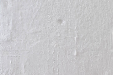 Fototapeta premium Gray background in the form of a fragment of a plastered wall and whitewashed with chalk. The texture of the plaster is close-up.