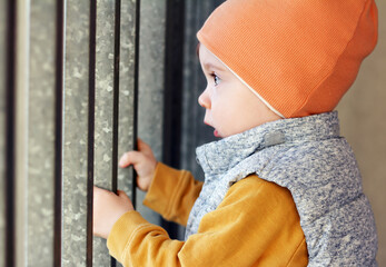 One-year-old baby holding onto the gate in Gdynia, Poland