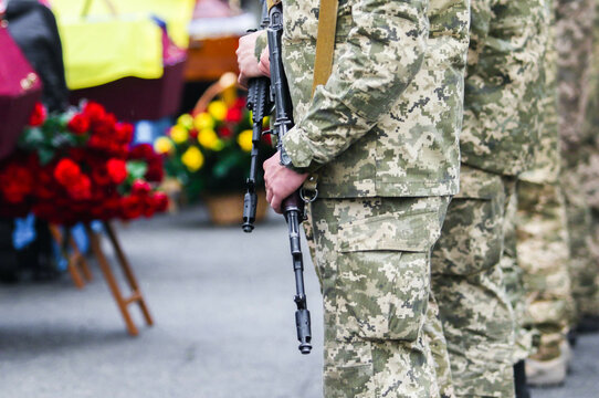 POLTAVA, UKRAINE - APRIL 19, 2022: Ukrainian military with a machine gun during the burial ceremony of fallen soldiers of the Armed Forces