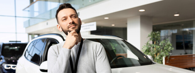middle-aged man thinking about buying a new car