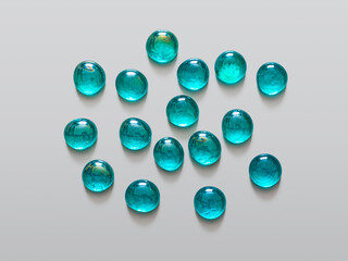 Shiny decorative turquoise glass beads on a light background