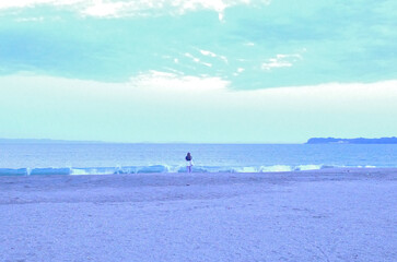 夕暮れ時の淡い美しい海辺とたたずむ女性