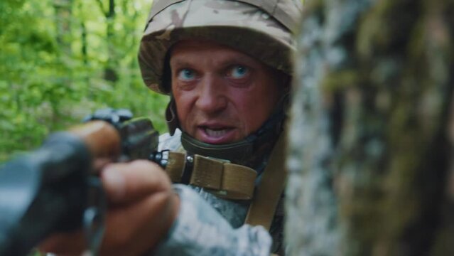 Portrait man soldiers with helmet and uniform holding machine gun forward to attack enemy in forest. Machine gun barrel look at camera