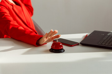 Female hand tends to press the red button on the desktop.