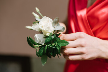 Bridesmaid in red dress holding bouquet. Closeup