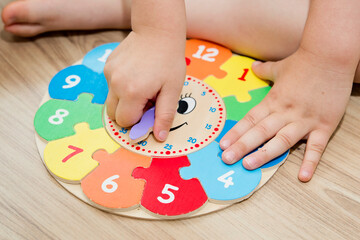 Boy learning time with wooden clock. Toy for Learning method for Children Education. Preschool or special needs tasks. Montessori methodology.