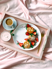 Cheesecakes and coffee on a tray. breakfast in bed,