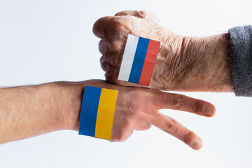 Ukraine war concept- two hands with ukrainian and russian flag playing rock paper scissors