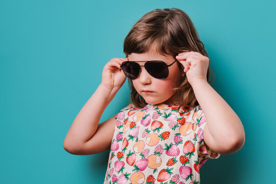 Girl putting on trendy sunglasses