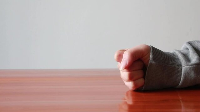close up fist of angry woman on the table