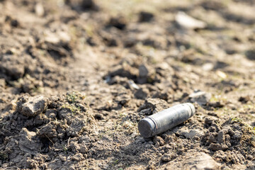 Unexploded ordinance (shell, missile) after invasion on the ground after battle in the village.War of Russia against Ukraine. Concept of invasion and aggression. - obrazy, fototapety, plakaty