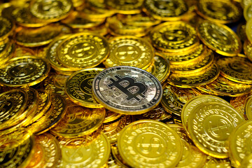 Golden bitcoin cryptocurrency on pile gold coins a lot of