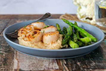 Pan-fried scallops with cauliflower and bean puree and asparagus